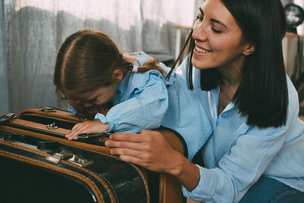 mom and daughter smiling with luggage ready for a trip