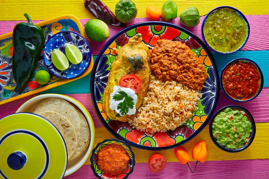 Classic Aztec Mexican cuisine consisting of beans, rice, peppers, salsas, guacamole, tortilla, and lime